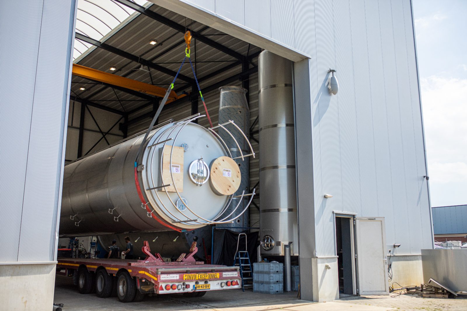 RVS tank van SRA Bolsward wordt op een dieplader geladen voor transport